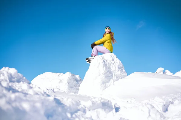 Wesoła Dziewczyna Snowboardzistka Żółtej Kurtce Przed Śnieżnymi Górami Błękitnym Niebem — Zdjęcie stockowe