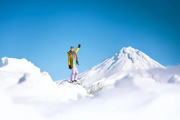 Fröhliche Snowboarderin Gelber Jacke Vor Verschneiten Bergen Und Blauem Himmel — Stockfoto