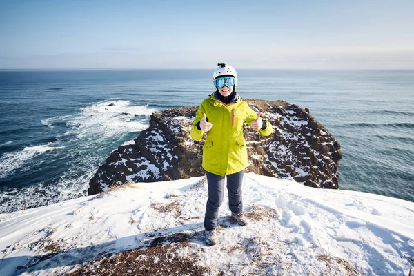 穿着绿色外套的年轻女游客看着太平洋边的相机 俄罗斯堪察加半岛 — 图库照片
