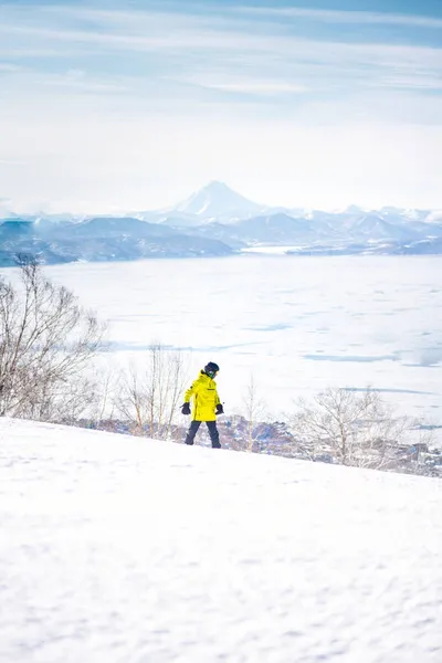穿着黄色夹克的滑雪者女孩骑着马下山 面对着雪山蓝天 — 图库照片