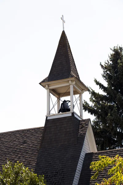Круглая деревянная церковь с крестом и колоколом — стоковое фото