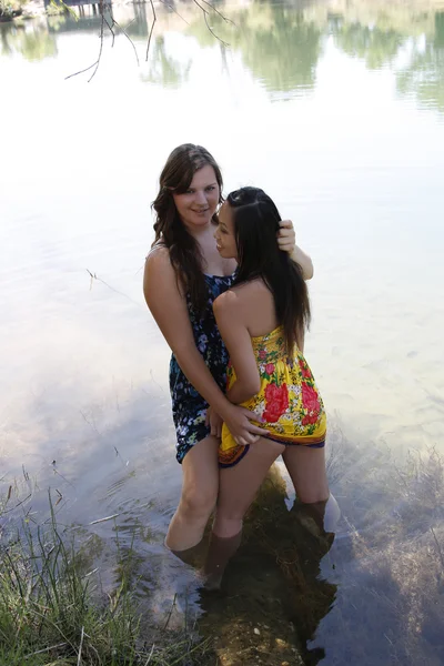 Twee vrouwen in rivier bedrijf jurk zomen — Stockfoto