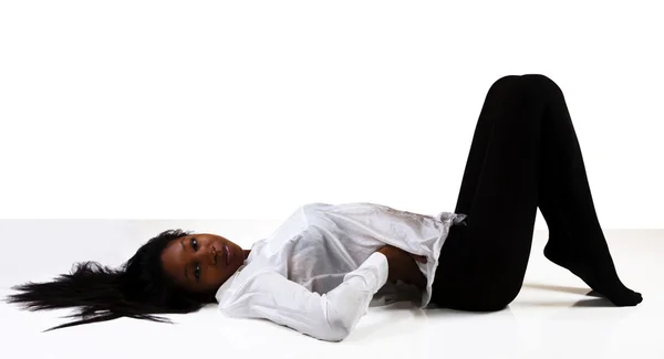 Unga afroamerikanska kvinna liggande strumpor skjorta — Stockfoto