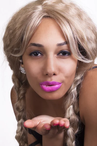 Молодая смешанная женщина отсасывает парик блондинки поцелуя — стоковое фото