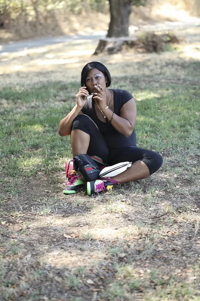 Black Woman Sitting on Ground Outdoors Smoking — Stock Photo, Image