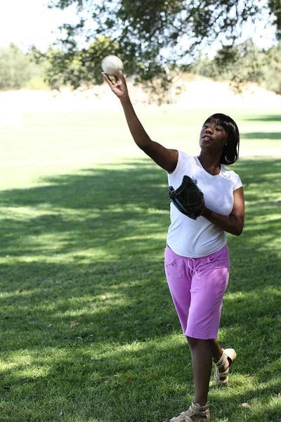 Joven mujer afroamericana lanzando béisbol Park — Foto de Stock