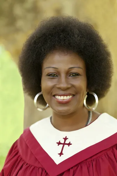 Orta yaşlı bir kadın açık havada kırmızı kilise bornoz gülümseyen