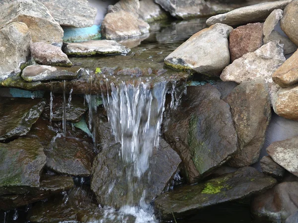 Рукотворний кам'яний водоспад фонтан ставок на відкритому повітрі мох — стокове фото