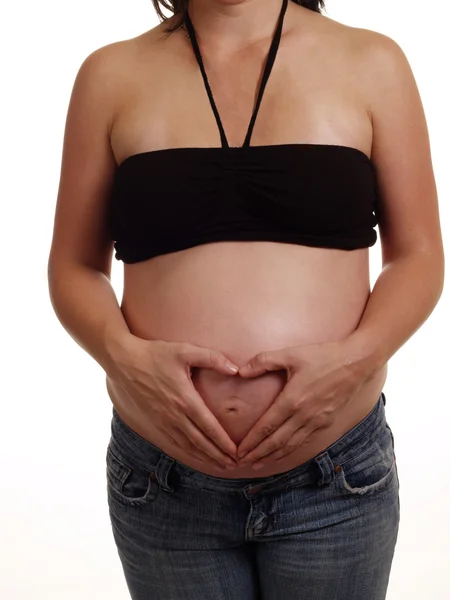 Mujeres embarazadas manos sobre el corazón del vientre grande —  Fotos de Stock