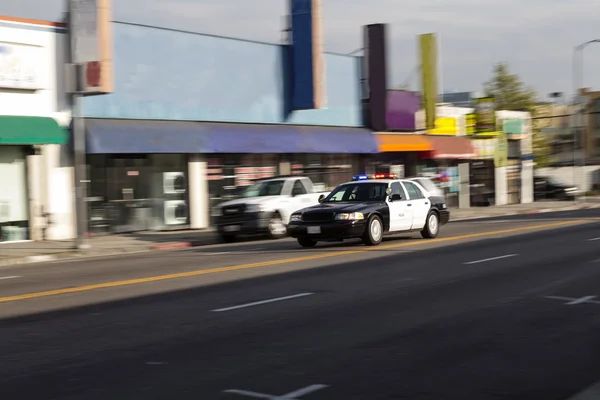 Pojedynczy policji samochód światła idąc w dół ulicy — Zdjęcie stockowe