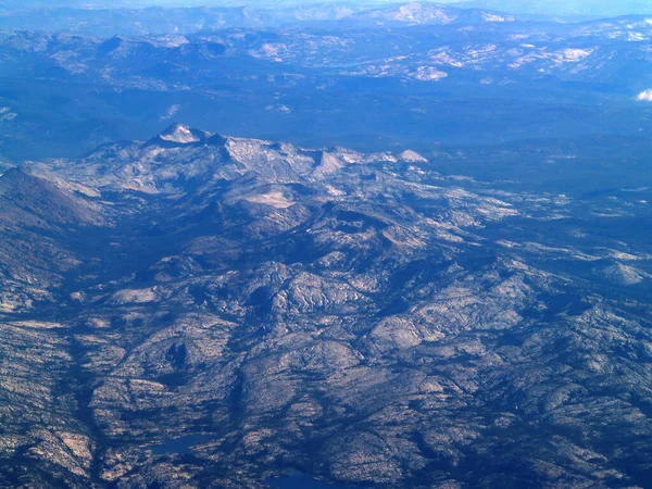 多雪背景下的光秃秃的岩石山脉的空中射击 — 图库照片