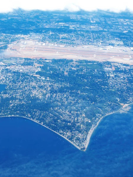 Aerial Photo Sharp Point Land Extending Ocean Dwellings Clouds — Stock Photo, Image