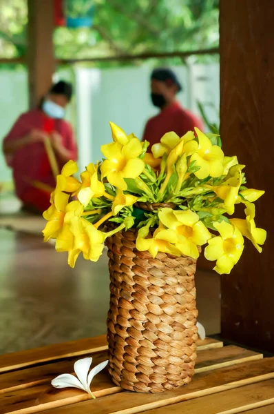 Bouquet Fiori Gialli Collocato Vaso Rattan Tradizionale Con Persone Abbigliamento — Foto Stock