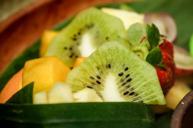 Tepside dilimlenmiş taze tropik meyve resmi. Kivi, mango, vs..
