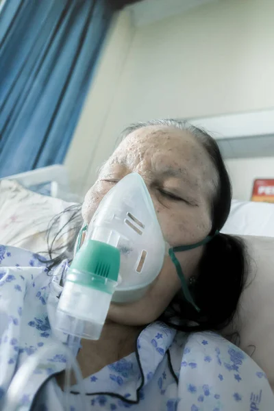 Asian Female Senior Patient Hospitalized Undergoing Respiratory Treatment Using Nebulizer Stock Image