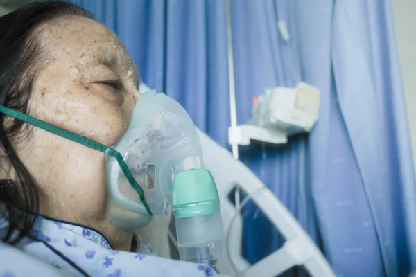 Asian Female Senior Patient Hospitalized Undergoing Respiratory Treatment Using Nebulizer Stock Image