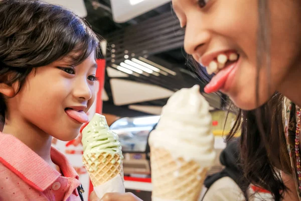 동남아시아의 어린이들 소녀들은 코너에서 녹차와 바닐라 아이스크림을 즐긴다 — 스톡 사진