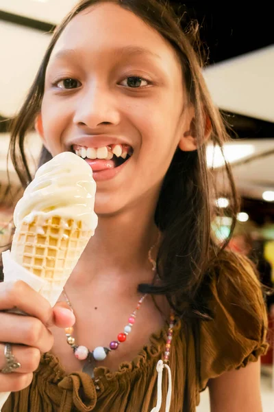 동남아시아의 소녀는 쇼핑센터에서 바닐라 아이스크림을 먹는다 — 스톡 사진