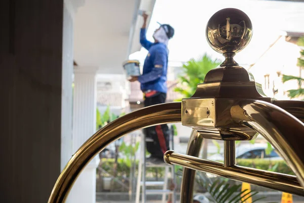 Carro Equipaje Vestíbulo Del Hotel Con Trabajador Masculino Repintando Patio Fotos de stock libres de derechos