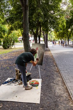 Debrecen Macaristan 20 Ağustos 2021: Tanımlanamayan ressam her yıl düzenlenen Halk Çiçek Festivali 'nde resim yaratırken, insanlar çalışmalarını izliyorlar.