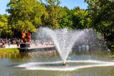 Debrecen Macaristan 20 Ağustos 2021: Küçük bir göletin ortasındaki çeşme. arka plandaki insanlar.