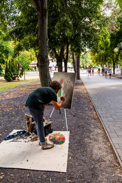 Debrecen Macaristan 20 Ağustos 2021: Tanımlanamayan ressam her yıl düzenlenen Halk Çiçek Festivali 'nde resim yaratırken, insanlar çalışmalarını izliyorlar.