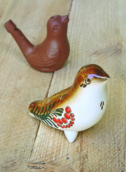 Two folk whistle-birdies from clay on a wooden plane. — Stock Photo, Image