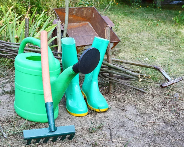 Instrumenty dla pracy w ogrodzie jest konewki, gumowe kolana- — Zdjęcie stockowe