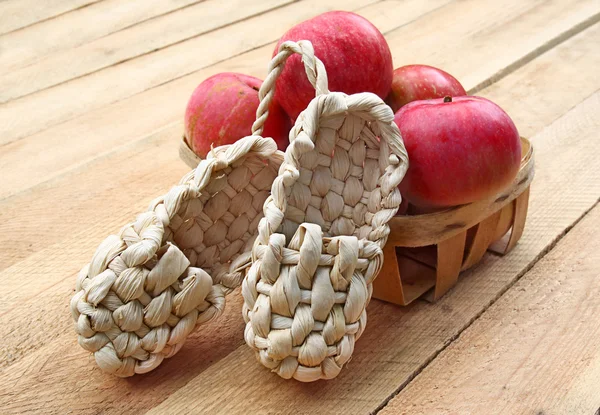 Bodegón rural con manzanas y sandalias de corteza —  Fotos de Stock