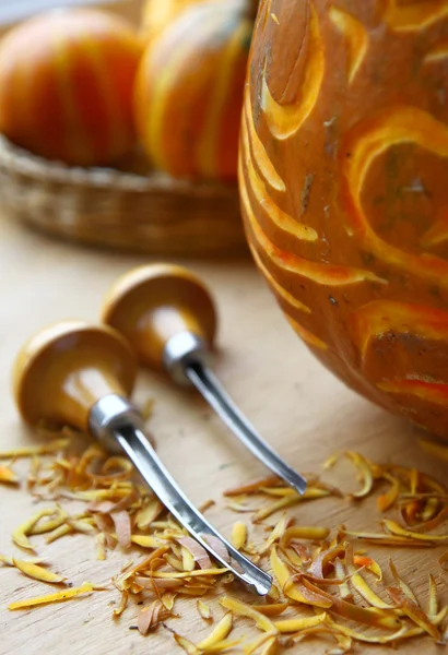 Pumpkin and tools for excision on a wooden surface — Stock Photo, Image