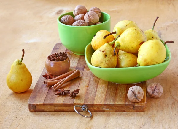 梨、 核桃、 肉桂、 姜木制的桌子上 — 图库照片