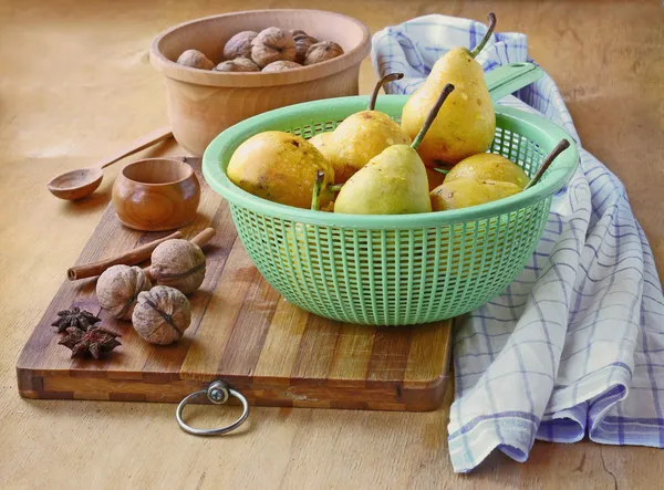 Pêras, nozes, canela e gengibre em uma mesa de madeira — Fotografia de Stock