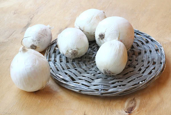 A white onion on the weaved round — Stock Photo, Image