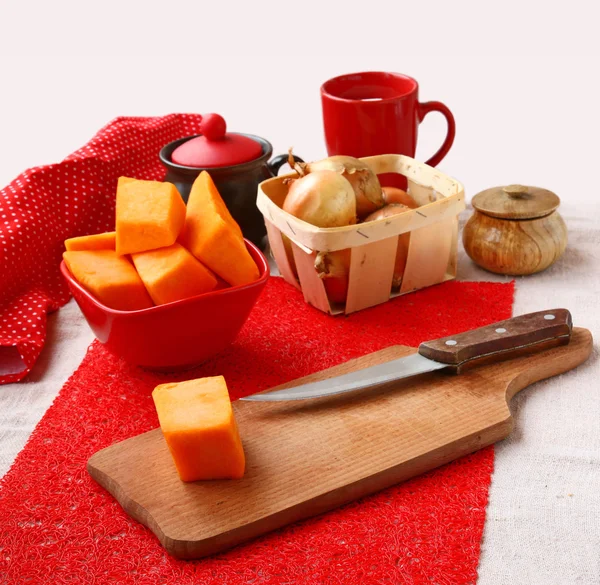 Ruwe pompoen en uien op een keukentafel — Stockfoto