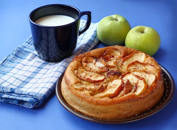 Gâteau aux pommes fait maison et tasse bleu foncé au lait — Photo