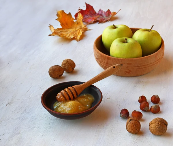 Яблоки, мед и орехи на белом столе — стоковое фото