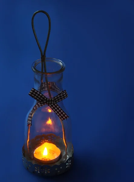 Lampe-lanterne avec une bougie sur fond bleu foncé — Photo