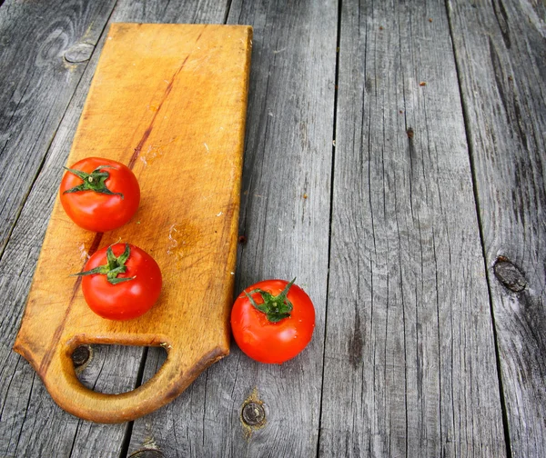 Red tomato on vintage table — Stock Photo, Image