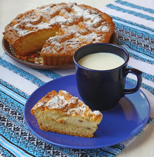 Tarta de cuajada y taza con leche —  Fotos de Stock