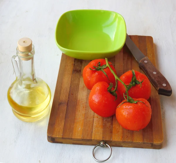 Lege bowl voor sla en tomaat naast de fles olijfolie oi — Stockfoto