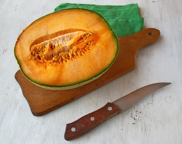 Half of pumpkin with a knife on table — Stock Photo, Image