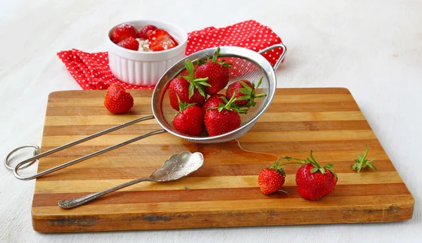 Fresh strawberries and spoon on a kitchen board — Stock Photo, Image