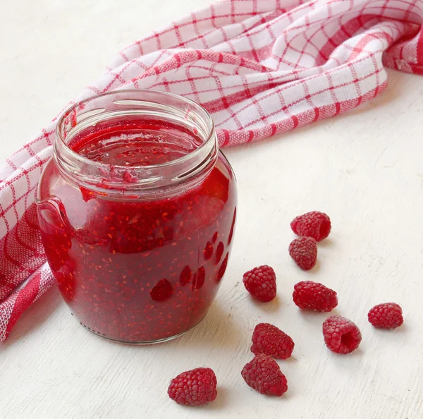 Barattolo con marmellata di lamponi sul tavolo — Foto Stock