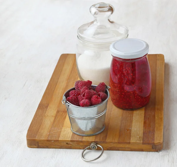 Raspberry on a background of of cans of jam and sugar — Stok Foto