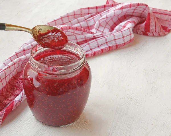 Banca con marmellata di lamponi sul tavolo — Foto Stock