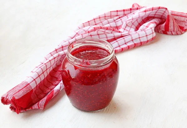 Open a jar with raspberry jam on the table — Stock Photo, Image