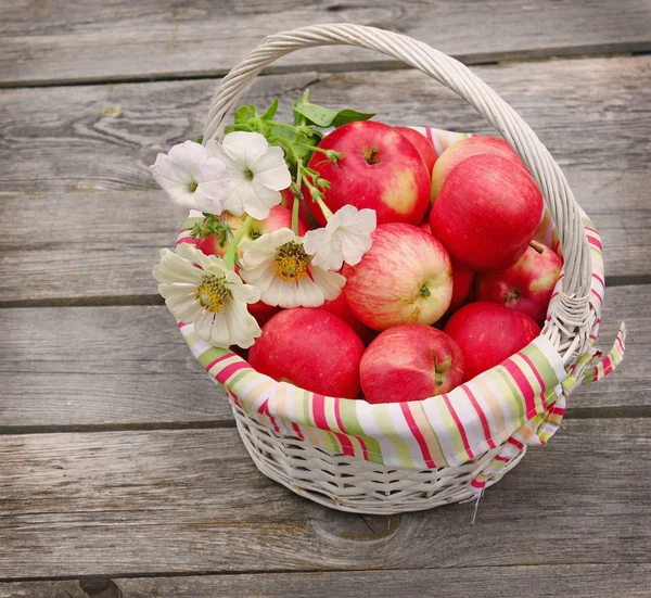 Cesta con las manzanas y montón de zinnia —  Fotos de Stock