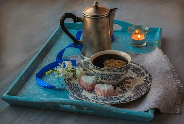 Чашка кофе с цветком и горящая свеча — стоковое фото