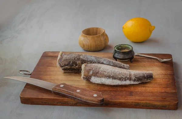 Seehecht silbrig und Messer auf einem Tisch — Stockfoto