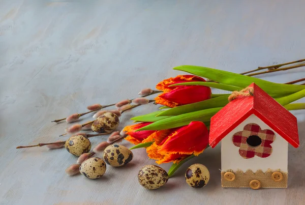 Easter eggs with birdhouse and spring flowers — Stock Photo, Image